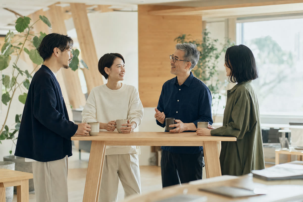 朝の光が入るオフィスで、社員の健康づくりの計画を話し合う小さな会社のチーム