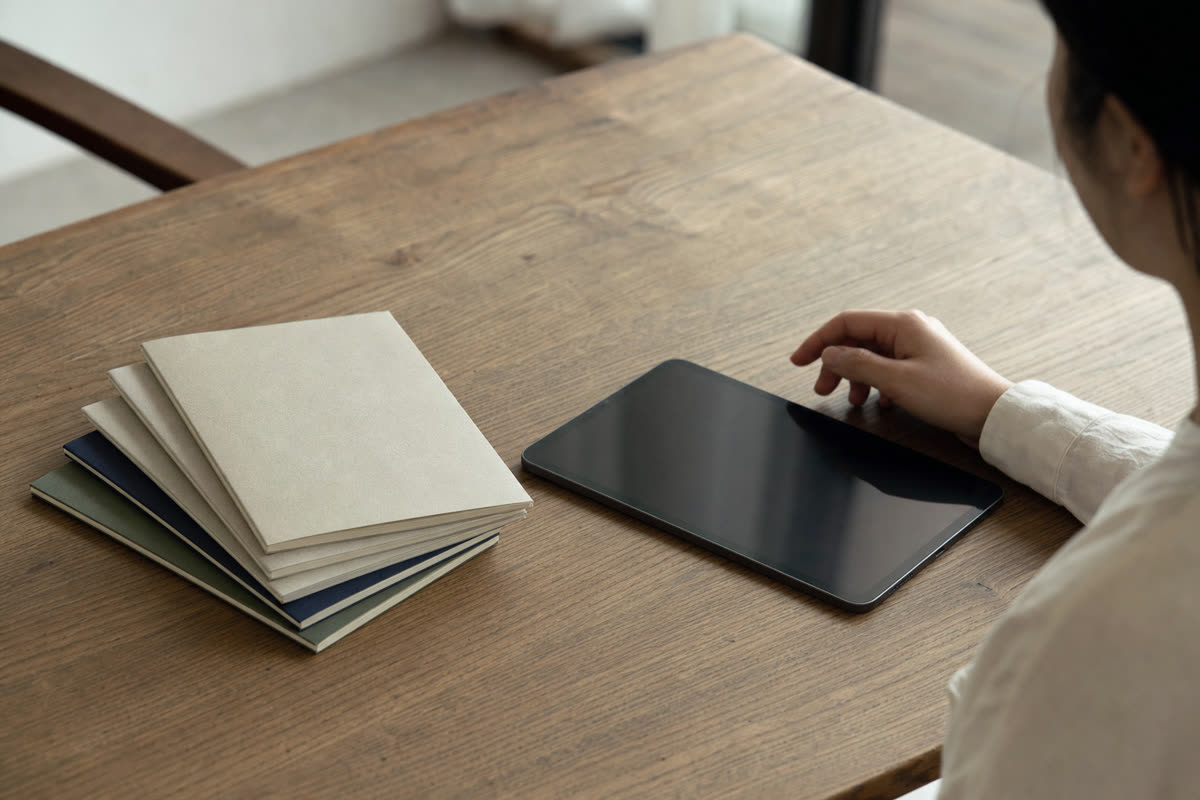 多言語で書かれた就業規則の冊子と、通訳アプリを入れたタブレット