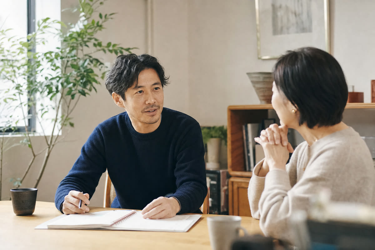 親の介護の予定を書いた手帳を見ながら、上司と勤務の組み方を相談する中堅社員
