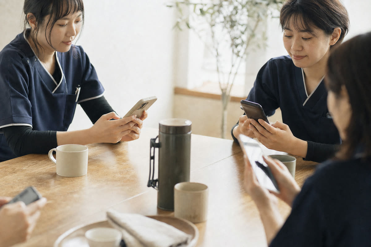 休憩時間にスマートフォンで職場アンケートに答える社員たちの手元