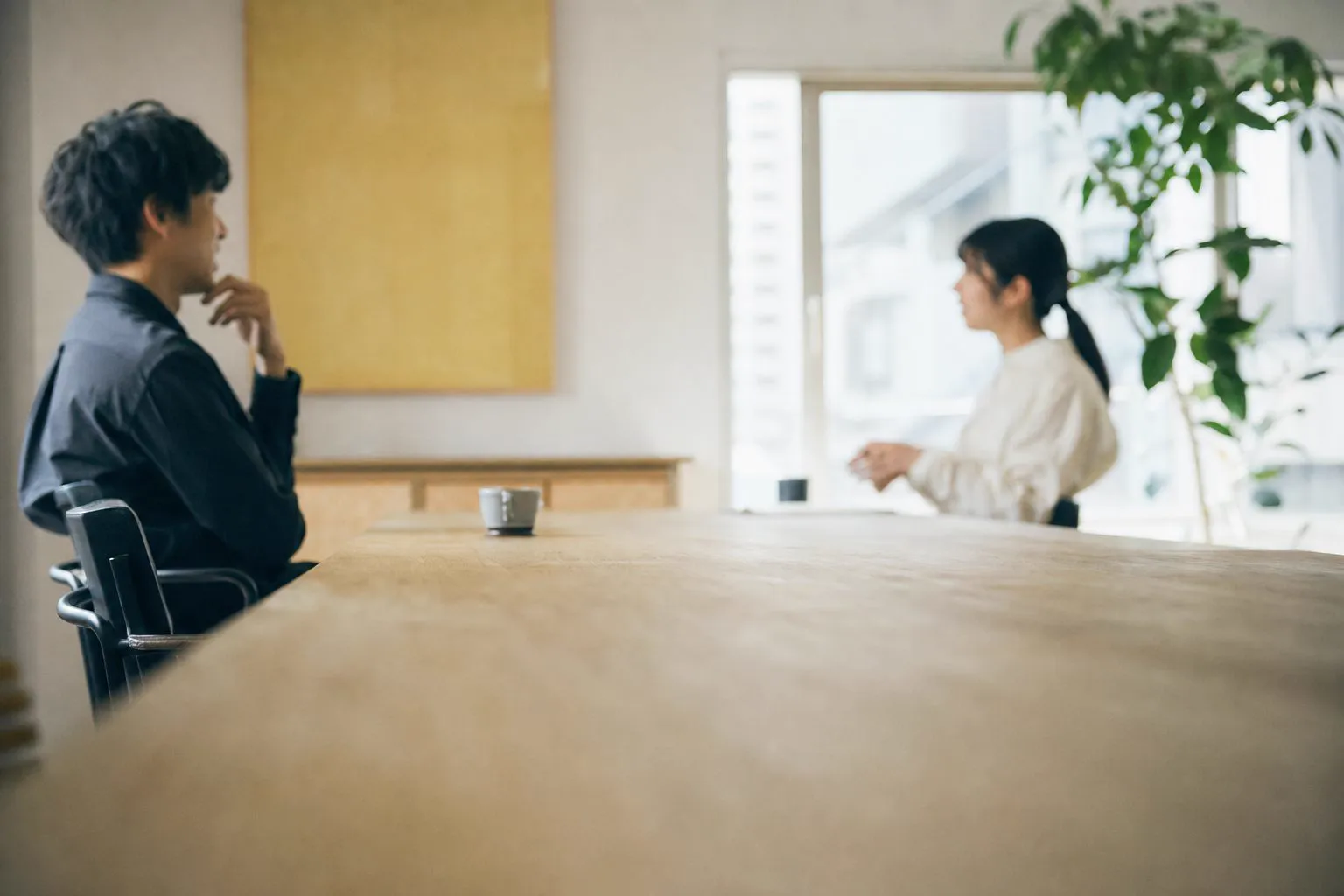 事業所の事務室で、会議用のまとめを見ながら話し合う管理者たち（イメージ）